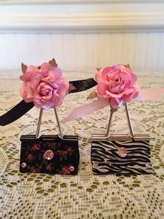 two pink roses are placed on top of black and white boxes with zebra print ribbon