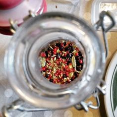 a glass jar filled with food sitting on top of a table next to a plate