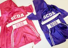 two pink and purple soccer uniforms laying on top of each other