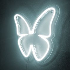 a butterfly shaped neon sign hanging from the side of a wall in a dark room