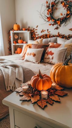 a bedroom decorated for fall with pumpkins and candles