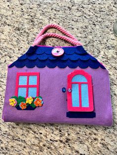 a purple felt house sitting on top of a counter