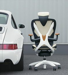 an office chair sitting next to a white car