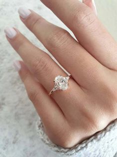 a woman's hand with a diamond ring on it