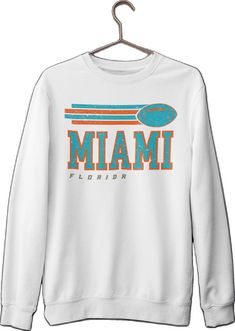 White Long Sleeve T-shirt For Sports Season, White Long Sleeve College T-shirt, White Long Sleeve T-shirt For College, White Long Sleeve Fan Apparel Sweatshirt, White Tops With Team Spirit For Fall, White Tops For Fall With Team Spirit Style, White Collegiate T-shirt For Fall, Collegiate White T-shirt For Fall, Long Sleeve Varsity T-shirt For Fans