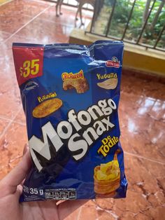 someone holding up a bag of mofong msnax tortilla chips