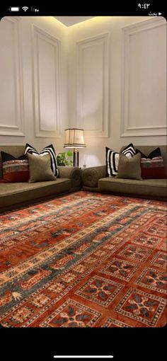 a living room with two couches and a rug on the floor in front of it