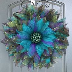 a blue and green wreath with peacock feathers