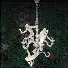 a white chandelier with monkeys hanging from it