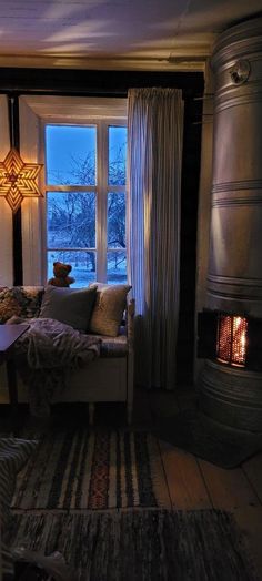 a living room filled with furniture and a fire place next to a large open window