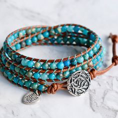 Genuine leather and turquoise jasper gemstones make up this classic boho style, three layer wrap bracelet. Always a favorite ~ and when you think bohemian, you think turquoise! Turquoise looks gorgeous on every skin tone. Give it a try and enjoy the versatility. 4mm (.157") diameter turquoise jasper gemstones Silver finished bamboo leaves motif button, about 16mm (5/8") in diameter Rust brown leather Signature Bluefish logo heart charm 34 - 39 cm/13.5 - 15.5" length 3 button loop adjustments to Turquoise Wrap Bracelet, Jasper Gemstone, Bead Leather, Leather Wrap Bracelet, Leather Wraps, Diy Bracelets, Heart Charm, Wrap Bracelet, Turquoise Bracelet