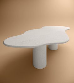 a large white table sitting on top of a brown floor next to a tan wall