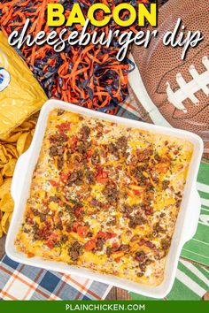 bacon cheeseburger dip in a casserole dish with chips and footballs