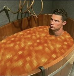 a man sitting in a wooden tub with orange tiles on the bottom and sides, looking off into the distance