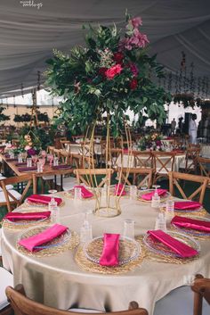 the table is set with pink napkins and place settings for guests to sit at