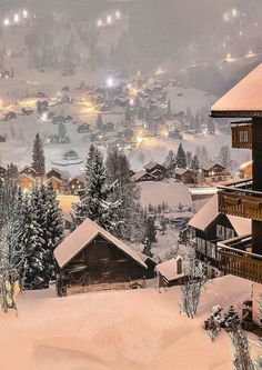 an image of a snowy mountain town at night with lights in the trees and snow on the ground