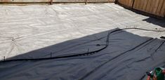 an outdoor trampoline is being installed in the back yard with tarps on it