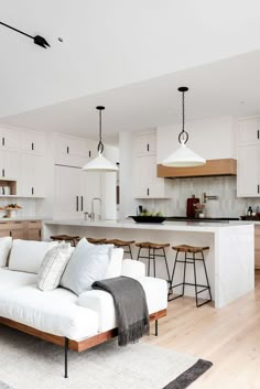 a living room filled with furniture next to a kitchen