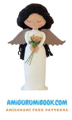 a crocheted angel doll with flowers in it's arms and wings, holding a