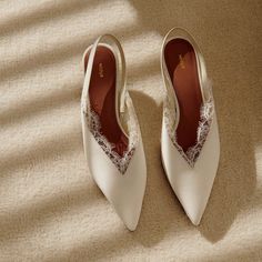 a pair of white shoes sitting on top of a carpet