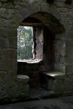 an open window in the side of a stone building with steps leading up to it