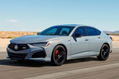 a silver acura is driving down the road