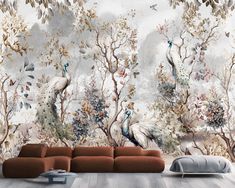 a living room with a couch and wallpaper that has birds on it in the background