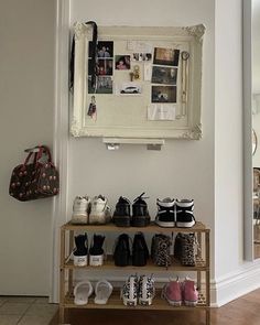 shoes are lined up on a shelf in front of a wall with pictures and photos