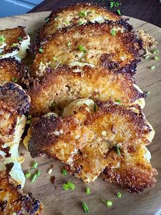 some fried food on a wooden plate with parsley sprinkled around it's edges