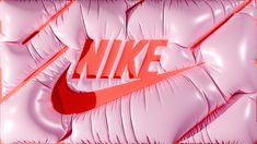 the nike logo is on top of some shiny pink material that looks like it has been folded over