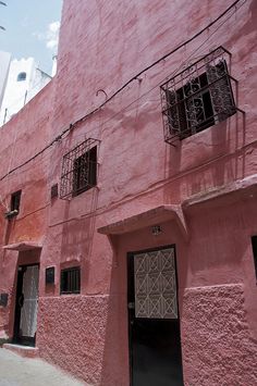 a pink building with black doors and windows