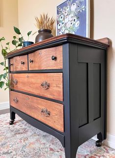 an old dresser is painted black and brown