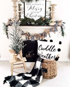 a fireplace decorated for christmas with black and white plaid stockings, greenery and a sign that says cuddle weather