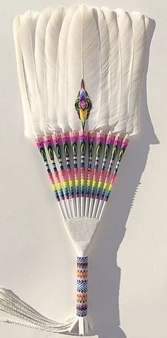 a bunch of white feathers on top of each other with different colors and shapes in them