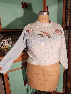 a mannequin wearing a sweater with roses on it