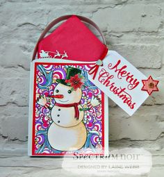 a christmas card with a snowman on it and a tag hanging from the front