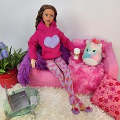 a barbie doll sitting on top of a pink chair