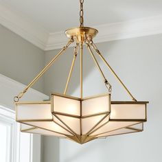 a chandelier hanging from the ceiling in a room with white walls and windows