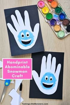 two handprinted snowman crafts on a table