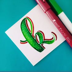 a green and red pen sitting on top of a piece of paper next to a marker