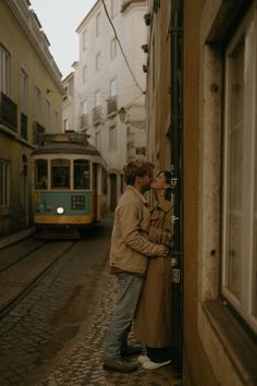 two people standing next to each other near a train