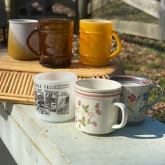 three coffee cups sitting on top of a wooden table