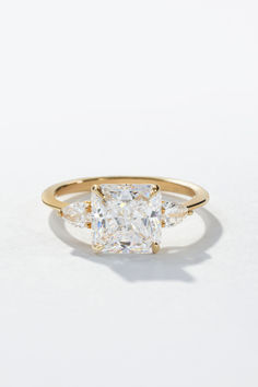 a gold ring with three pear shaped diamonds