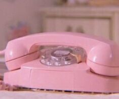 a pink phone sitting on top of a table