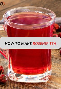 a glass mug filled with red liquid sitting on top of a wooden table next to cranberries