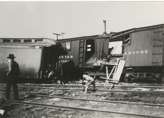 an old black and white photo of two men working on train tracks next to trains