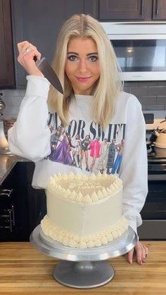 a woman holding a knife over a cake