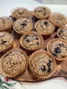 blueberry muffins sitting on top of a wooden cutting board