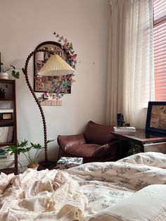 a bedroom with a bed, chair and lamp in it next to a book shelf