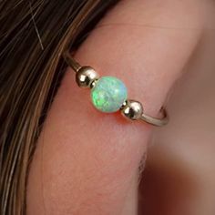 a close up of a person's ear with an opal stone on it